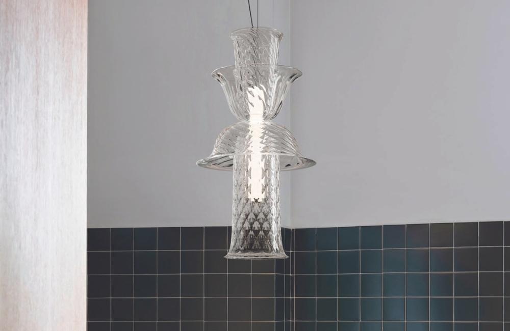 Campanula di Barovier&Toso, collezione di lampade a sospensione disegnata dal duo García Cumini che si sviluppa in verticale e con doppia fonte luminosa, una verso il basso e l’altra nella direzione opposta. Un effetto luminoso magnetico che rende protagonista il vetro