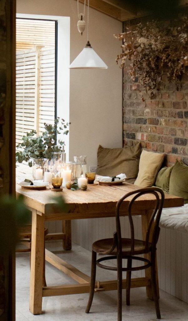 La tavola da pranzo tra la vetrata sul giardino e il muro di mattoni