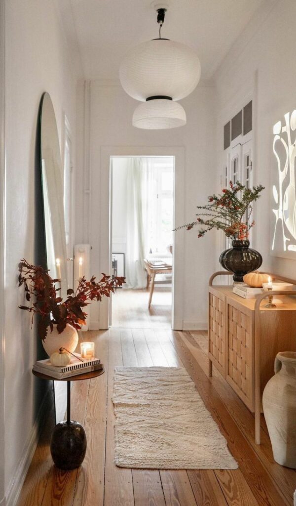 Un grande specchio, candele e mobili chiari fanno sembrare più luminoso anche il corridoio. Anche questo è hygge!