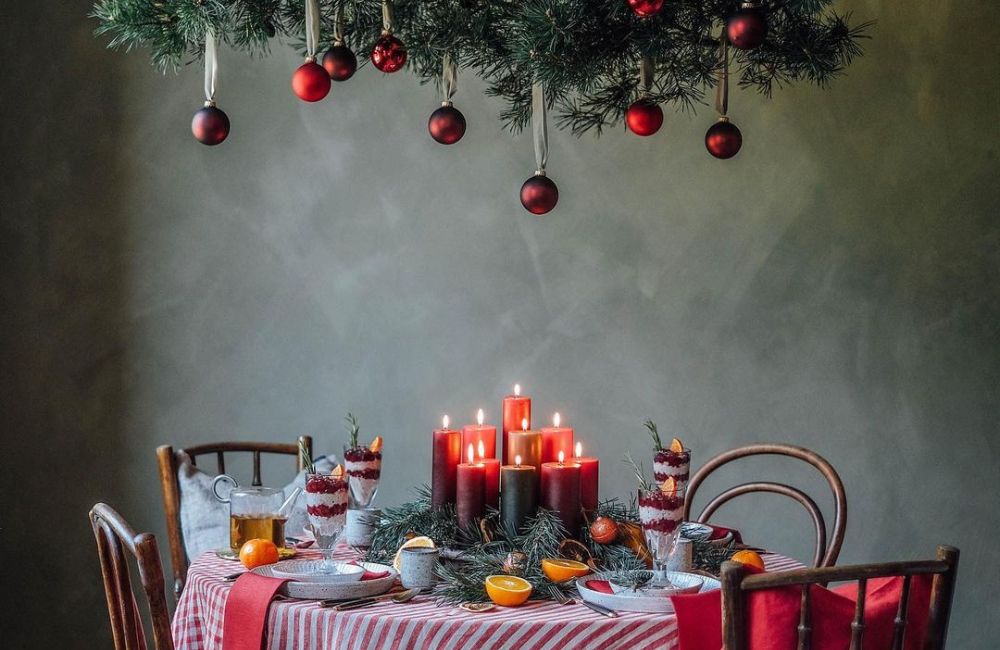 Una tavola di Natale giocata sui toni del rosso e sulla frutta di stagione