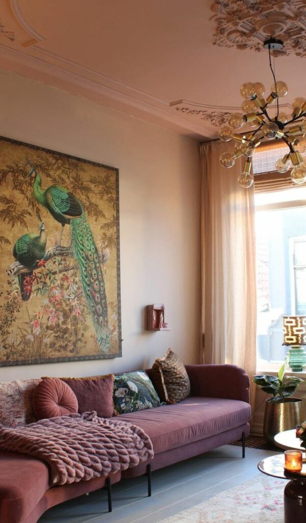 Una grande stampa su tela domina la parete color pesca alle spalle del divano rosa antico