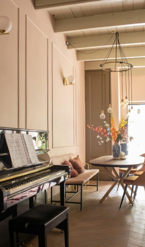 Un pianoforte verticale introduce la sala da pranzo con cucina a vista