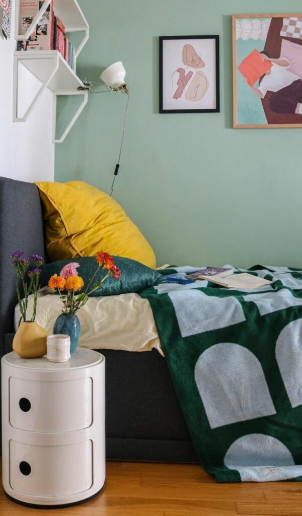 Piccoli vasi con fiori accanto al letto
