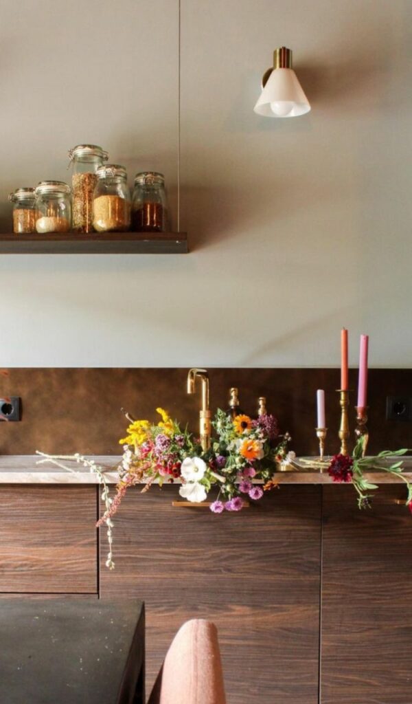 Fiori nel lavandino in cucina, essenziale con i suoi mobili in legno e la parete chiara