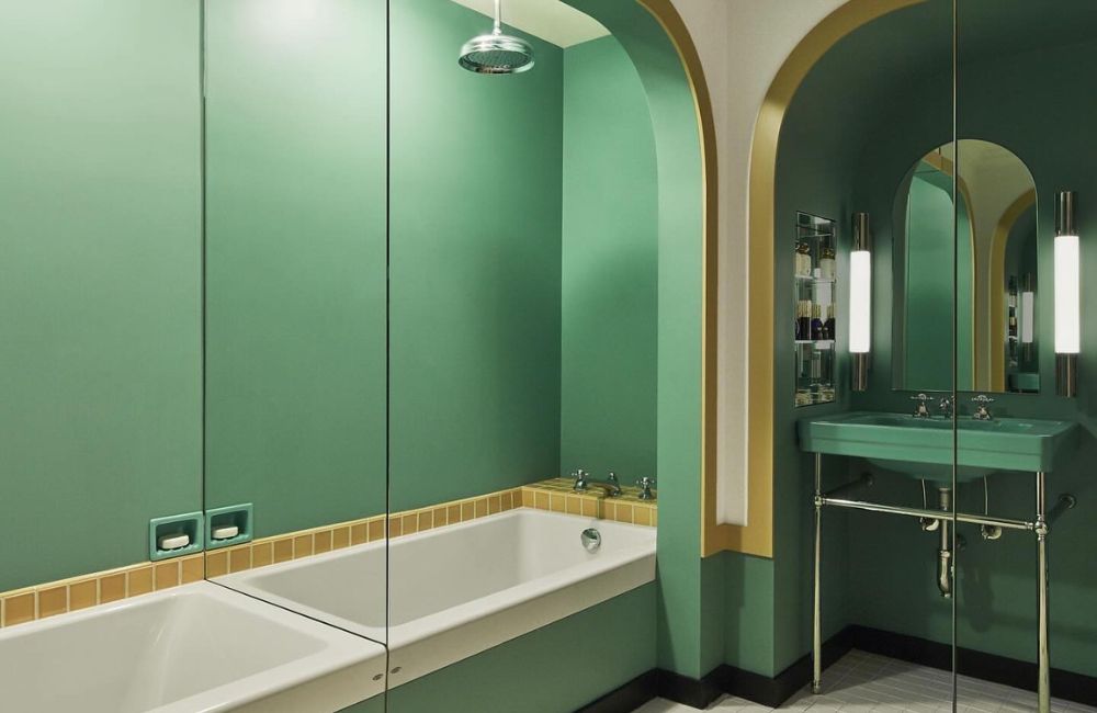 Anche il bagno si può arredare con gli specchi. Qui una intera parete riflette l'ambiente