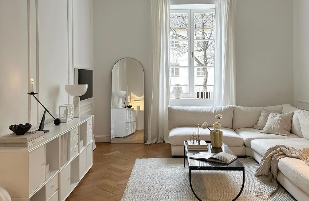Il gusto minimalista è la cifra distintiva del living, con divano, mobili e tappeto dalle linee pulite e le tonalità chiarissime
