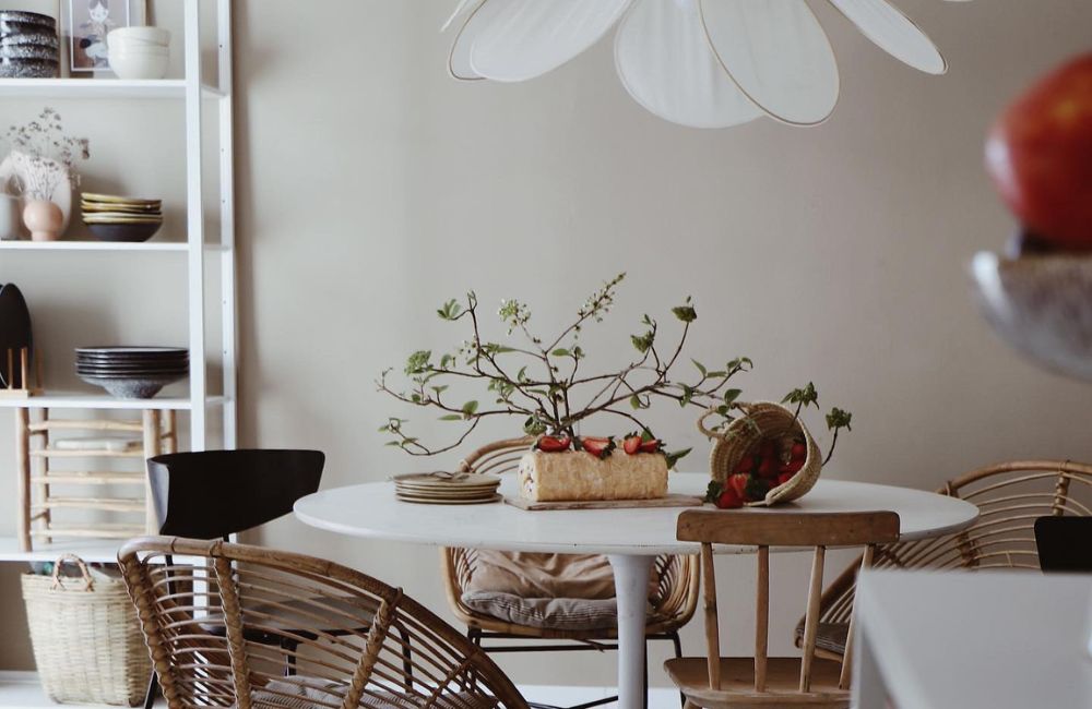 Le decorazioni vegetali non mancano mai neppure in sala da pranzo, sul tavolo bianco illuminato dalla lampada a fiore