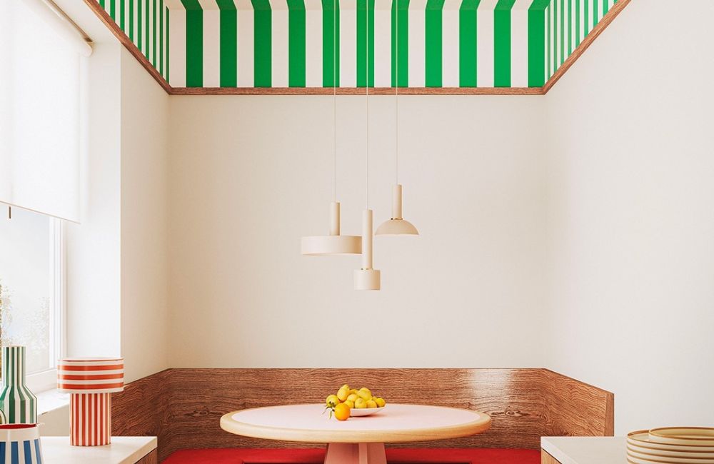 Una wallpaper a righe ricopre soffitto e parte alta di un angolo pranzo