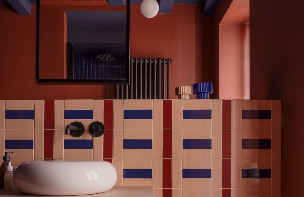 Un bagno bicolore giocato sull'abbinamento tra il mattone e il cobalto